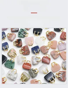 Macro display of assorted natural gemstone handbag pendants with gold metal handles