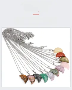 Detailed view of hand-carved natural crystal crescent moon face pendants in various stones