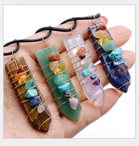 Detailed macro view of four chakra crystal pendants wrapped in copper wire with black cords