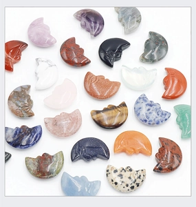 Flat lay of assorted carved natural crystal moon pendants in various gemstones and colors