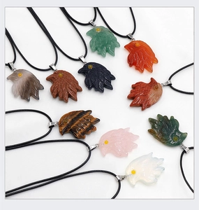 Detailoverzicht van handgesneden adelaarskop hangers in diverse natuurlijke edelstenen