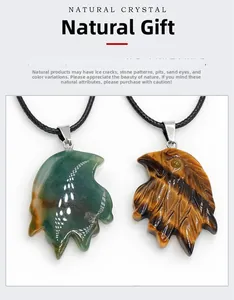 Detail van handgesneden adelaarskop hangers van tijgeroog en natuurlijke groene agaat