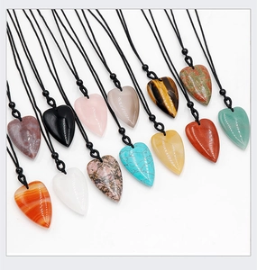 Twelve colorful heart-shaped natural stone pendants with black ropes on a white background