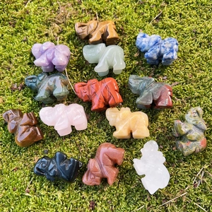 Mini figuras de elefantes en cristales naturales sobre fondo de musgo verde