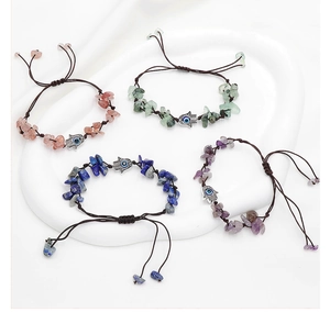 Dettaglio di braccialetti intrecciati in pietre naturali con ciondolo Hamsa e malocchio
