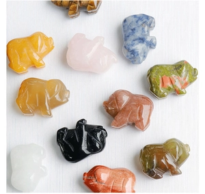 Macro shot of 1-inch mini pig figurines carved from various natural gemstone crystals