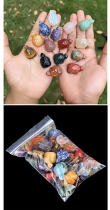 Macro shot of a hand holding various natural crystal turtle carvings to show mini size