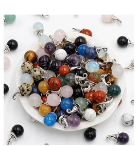 Macro view of assorted crystal stone spheres with silver metal caps in a white bowl