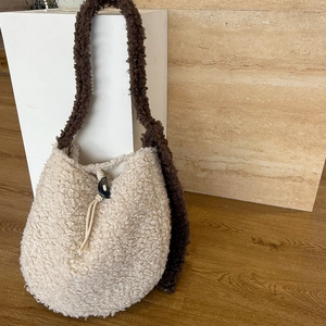 Detail of plush fleece shoulder bag showing cream texture and contrast brown strap