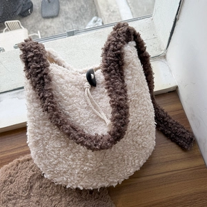 Detail of plush cream faux shearling bag with dark brown contrast trim and toggle closure