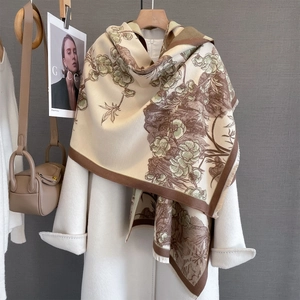 Détail de l'imprimé floral et franges sur châle beige épais au toucher cachemire