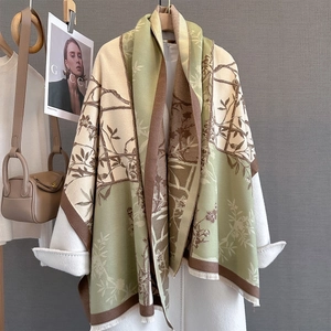 Detail of cashmere-feel tassel shawl with beige green floral patterns and soft textures