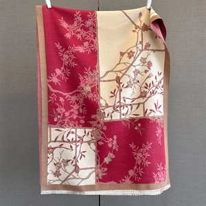 Detail of dark red and beige floral scarf showing fabric texture and white fringe
