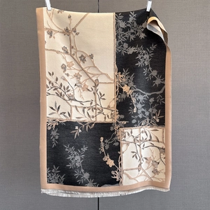Detail of elegant floral jacquard shawl featuring vintage patterns and soft tassel fringe