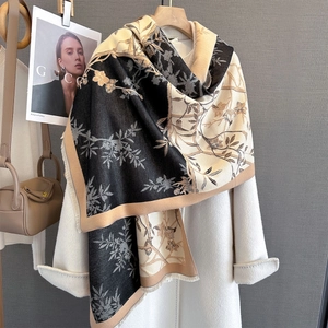 Detailed close-up of floral print scarf with soft fringe edges and premium knit texture