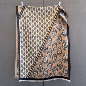 Close-up of paisley jacquard pattern and fringe details on earthy-toned pashmina shawl