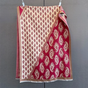 Detail of paisley jacquard cashmere shawl with fringe trim in burgundy and cream white