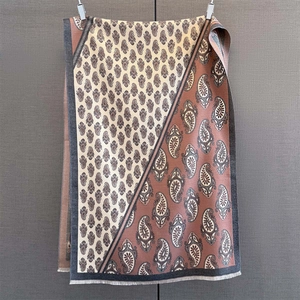 Detail of two-tone paisley print scarf with fringe edges and dual-color stitching