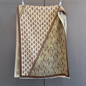 Close-up of paisley pattern scarf with fringe edges in beige and green tones
