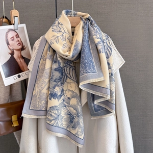Close-up of floral cashmere feel scarf with detailed fringe edges and navy botanical patterns