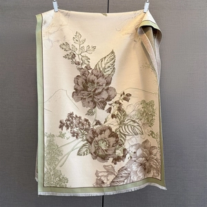 Close-up of vintage floral jacquard pattern and soft fringe tassels on a beige scarf