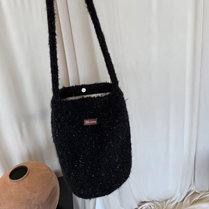 Sparkly black plush bucket bag with fuzzy texture and shoulder strap for winter fashion