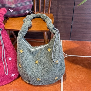 Detail der grauen Plüsch-Tasche mit Kordelzug und gelben Stern-Stickereien