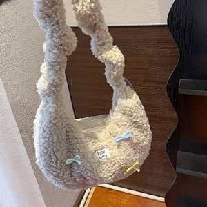 Gros plan sur la matière pelucheuse crème ornée de nœuds colorés en relief 3D doux