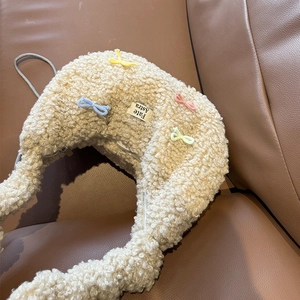Gros plan du sac cabas en peluche crème avec mini nœuds colorés et bandoulière chaîne