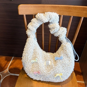 Détails de texture du sac en peluche blanc avec nœuds tricotés et étiquette Fate Astra