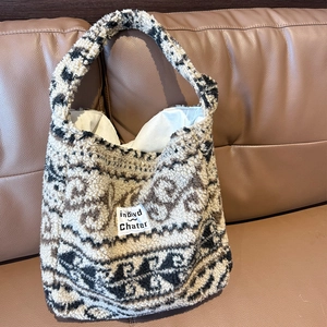 Dettaglio della borsa in pile Sherpa con motivo astratto ed etichetta in tessuto