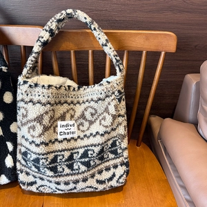 Dettaglio del motivo Fair Isle sulla grande borsa tote in pile appesa a una sedia
