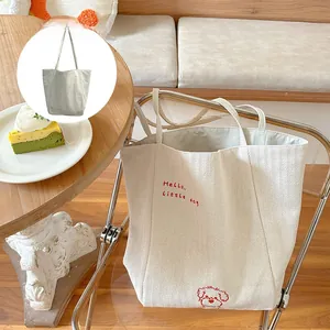 Detail of reversible herringbone canvas tote with cute dog embroidery and two-sided design