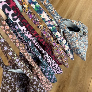 Détail de sacs cabas en velours côtelé à motifs léopard et fleurs avec bouton