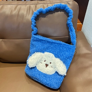 Detailed view of the blue plush fabric and white cartoon dog embroidery on the tote bag
