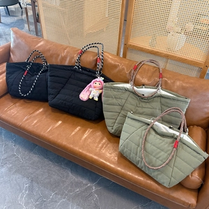 Quilted tote bags in black and olive green on a leather sofa, showing the braided handles
