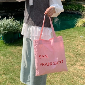 Detailed texture of pink canvas tote bag with red San Francisco letter print