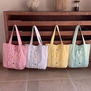 Détail de cabas colorés en nylon avec bordures à volants et boutons décoratifs centraux