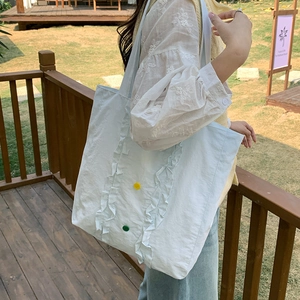 Détail du sac cabas en nylon bleu clair avec volants et boutons contrastés