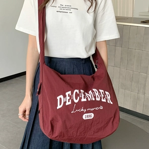 Sac hobo chic en nylon bordeaux pour femme avec typographie blanche et large bandoulière