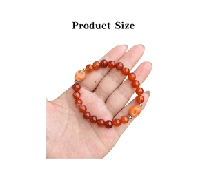 Detail view of 8mm natural stone beads and carved skull charms on an orange bracelet