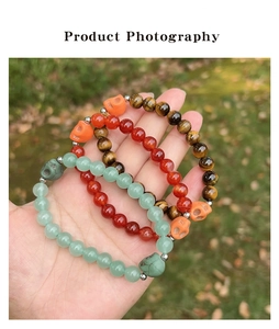 Three-piece amethyst and tiger eye 8mm bead bracelet set with skull charms in hand