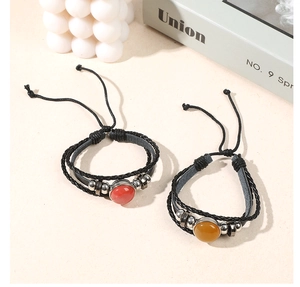 Close-up of adjustable braided leather bracelets with natural red and yellow agate stones