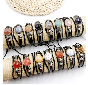 Detailed close-up of multiple vintage leather bracelets with colorful stone inlays on display
