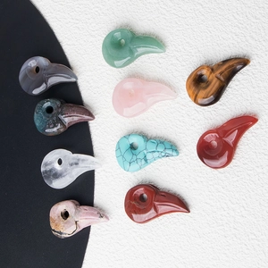 Detailed macro view of bird skull pendants carved from assorted natural healing stones