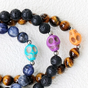 Stack of 8mm amethyst tiger eye stone bead bracelets with colorful skull accents