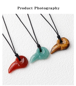 Macro detail of bird skull pendants carved from tiger eye, red agate, and aventurine stones