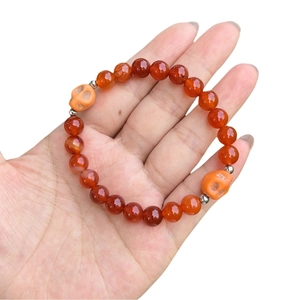 Beaded bracelet with 8mm tiger eye stones and skull charms on a hand model