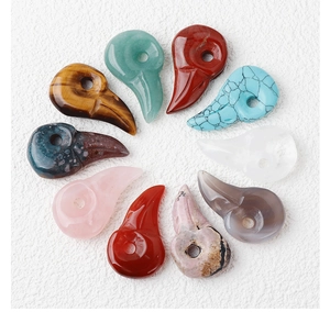 Detailed top view of various natural stone bird skull pendants arranged in a circular layout