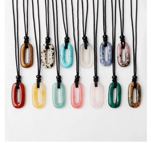 Détail de 13 pendentifs ovales en pierres naturelles variées avec cordons noirs perlés